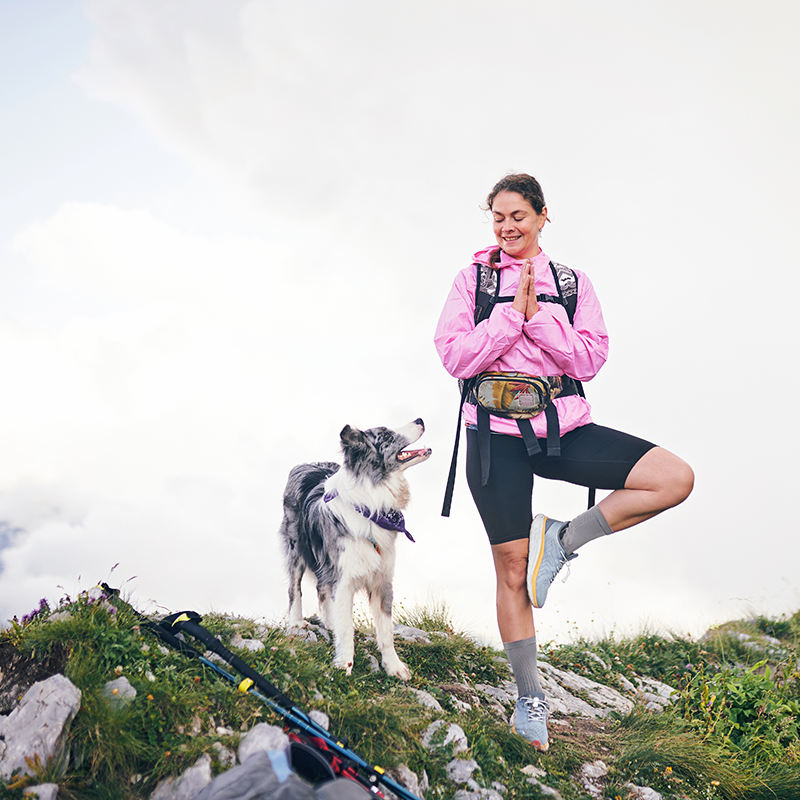 Woman enjoying an active lifestyle hiking with her dog, highlighting the importance of protecting her income