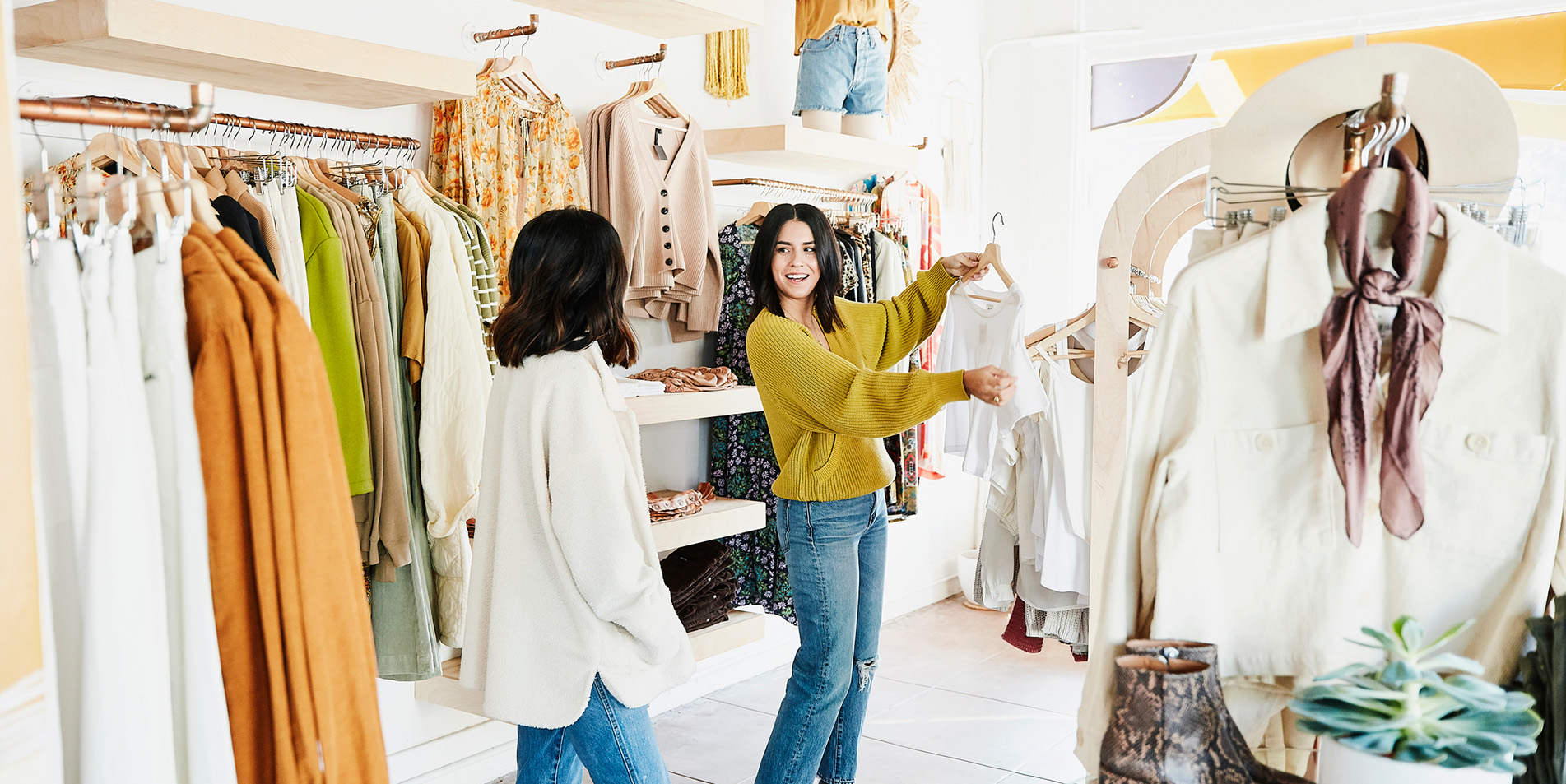 shop-owner-helping-smiling-woman-choose-outfit